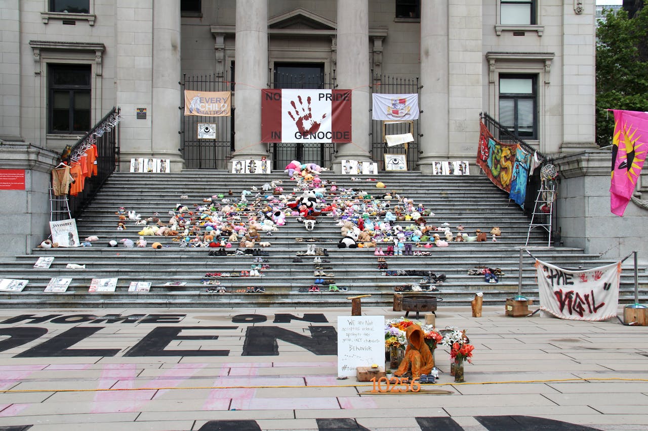 A memorial display with toys and banners at Vancouver Art Gallery highlighting social issues.